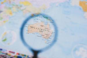 Magnifying glass over a map of Australia, selective focus photo