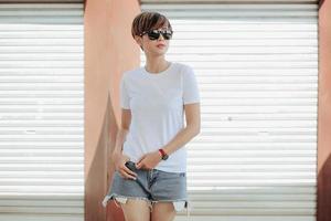 Mock up of white t-shirt and short pants with sunglasses wearing by beautiful stylish short hair woman photo