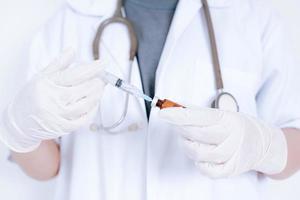 Cropped shot of doctor hand holds syringe and bottle with vaccine. Medicine, vaccination, immunization and healthcare concept photo