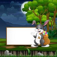 Easter bunny carrying a sack of easter eggs in front the blank sign vector