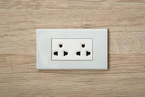 AC power plugs and sockets in wooden wall.