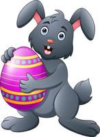 Cartoon bunny holding Easter egg vector