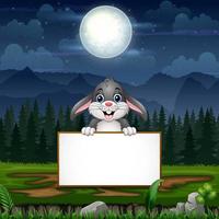 Cartoon a bunny holding blank sign under the full moon vector