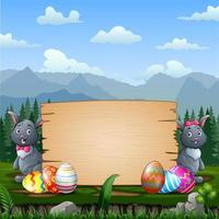 Happy Easter bunnies with Easter eggs by a wood sign board vector