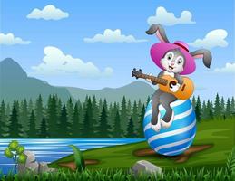 Cartoon rabbit playing guitar on a big Easter egg vector