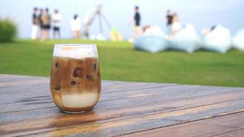 copo de café com leite gelado na mesa de madeira