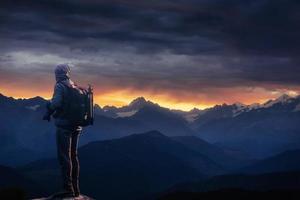 fotógrafo profesional toma fotos con una cámara grande en la cima de la roca