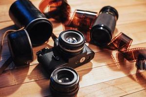 Old photo film and analog camera on table. Roll of photographic . Beautiful vintage design.