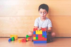 child playing with colored blocks photo