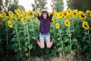 happy girl jumping in the field of sunflowers photo