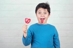 funny child with lollipop sticking out tongue photo