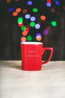 Merry Christmas.Christmas concept background.Red Cup with lights in blurred background photo