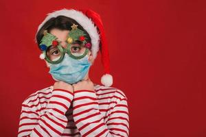 Merry Christmas, kid with medical mask and funny christmas glasses photo