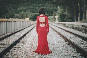 Back view of young woman on the train tracks photo