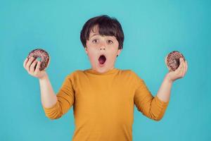 surprised boy with donuts in hands photo