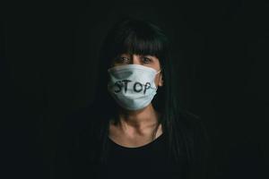 detener la violencia, mujer asustada con máscara médica para coronavirus víctima de violencia doméstica foto