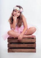 smiling girl sitting in a wooden box photo