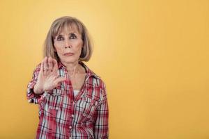 Portrait of Senior woman With Stop Gesture photo