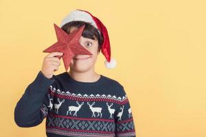 funny child who covers an eye with Christmas star photo