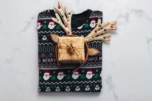 Merry Christmas. Top view of christmas sweater with bright Christmas toy deer antlers.Christmas concept background photo