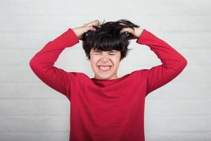 boy scratching his hair for head lice photo