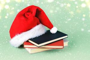 Merry Christmas. Santa's hat with books and Christmas lights. Christmas concept background photo