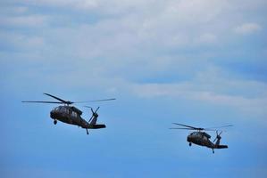 two military helicopters fly side by side photo