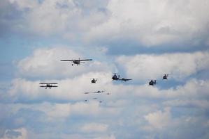 different airplanes and helicopters fly at an air show photo