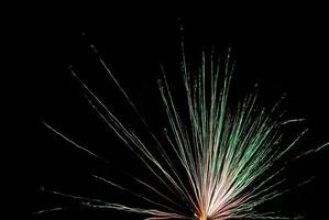 single high big green explosion at a fireworks in the night of new year photo