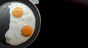 Two fried eggs in a teplon pan. photo