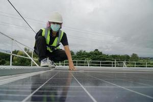 mujer de energía trabajando en un techo con paneles solares. foto