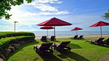 guarda-chuva com cadeira com fundo de praia do mar e nascer do sol de manhã - conceito de férias e férias