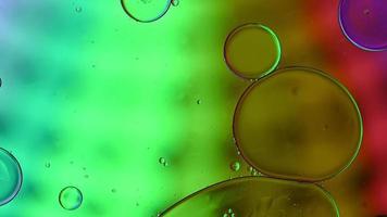 Abstract Colorful Food Oil Drops Bubbles and spheres Flowing on Water Surface, macro Videography video