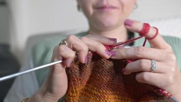 jeune femme tricote avec des boules colorées de laine et des aiguilles video