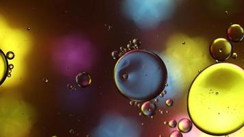 Abstract Colorful Food Oil Drops Bubbles and spheres Flowing on Water Surface, macro Videography video