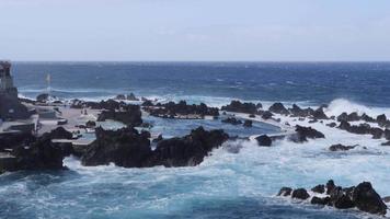 Natural pools in the middle of the Atlantic ocean in Madeira Island, Portugal. Amazing holiday times. Clouds with sun. Ocean and waves hitting the rocks. People in the water. video