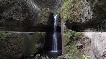 incrível cachoeira no fundo da montanha. túnel, passagem de caverna para caminhantes. sensação de selva. viajar o mundo. férias para momentos de relaxamento. video