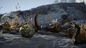un vieux ballon de football déchiré jeté se trouve sur le sable de la plage de la mer