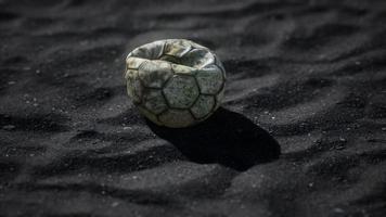 vecchio pallone da calcio sulla sabbia nera video