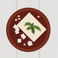 Tofu on wooden plate with soya beans and basil leaves top view vector