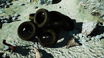 vieux pneus envahis par la végétation incrustés dans le sable video