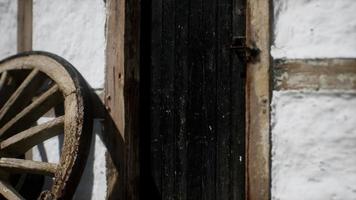 rueda de madera vieja y puerta negra en la casa blanca video