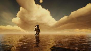 Raumfahrer im Meer unter Wolken bei Sonnenuntergang video