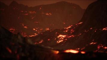 Red Orange vibrant Molten Lava flowing onto grey lavafield and glossy rocky land video