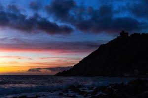 A castle by the sea silhouette at sunset photo