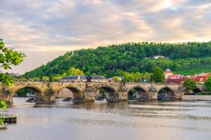 Charles Bridge Karluv Most with alley of dramatic baroque statues over Vltava river photo