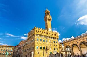 Palazzo Vecchio palace with bell tower with clock and Loggia dei Lanzi on Piazza della Signoria square photo