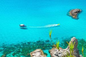 Fishing yacht and rubber boat in Capo Vaticano lagoon, Calabria, Italy photo