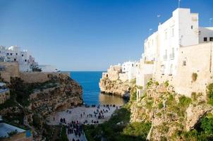 vista de la playa lama monachile cala porto y edificios blancos en grutas y acantilados en la ciudad de polignano a mare foto