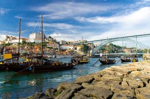 portugal, paisaje de la ciudad de porto, un grupo de botes de madera amarillos con barriles de vino en el río douro foto